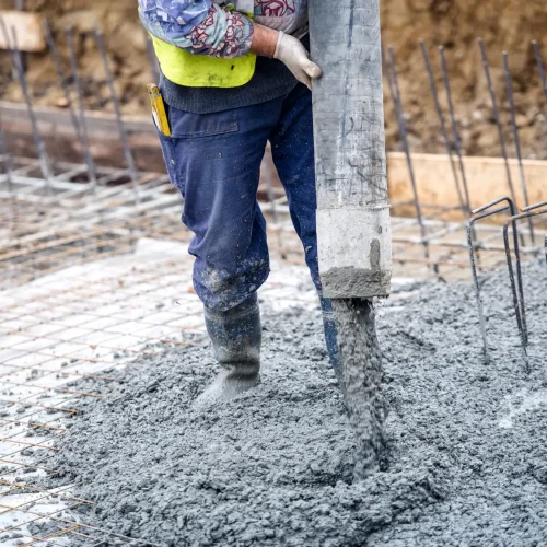 worker dropping the concrete mixture on floor